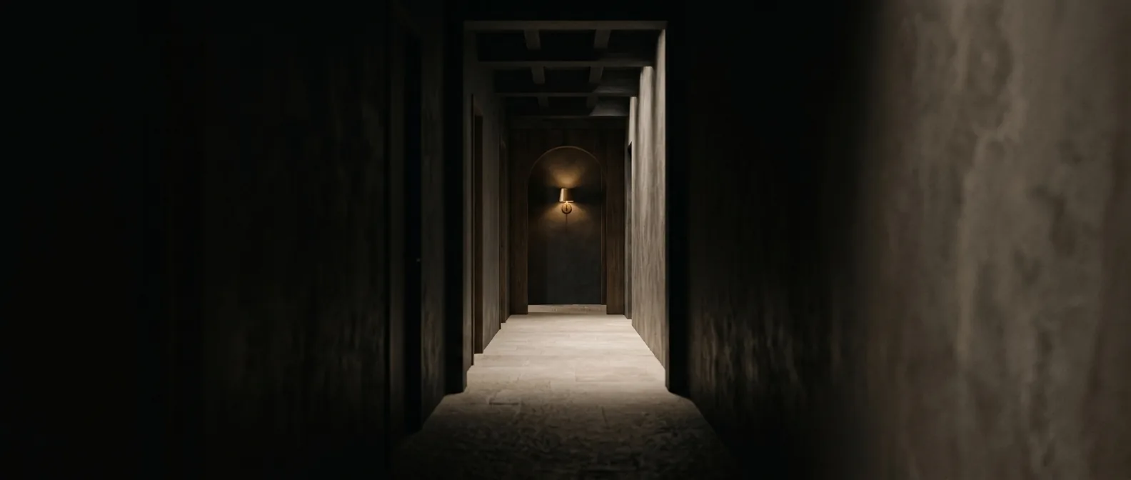 A dim treatment corridor lit by a brass sconce